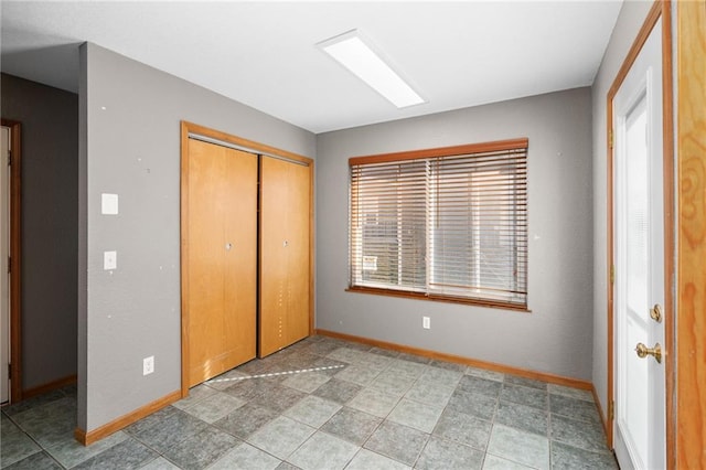 unfurnished bedroom featuring a closet and baseboards