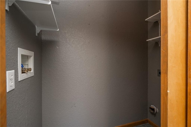 laundry room with hookup for an electric dryer, laundry area, and a textured wall