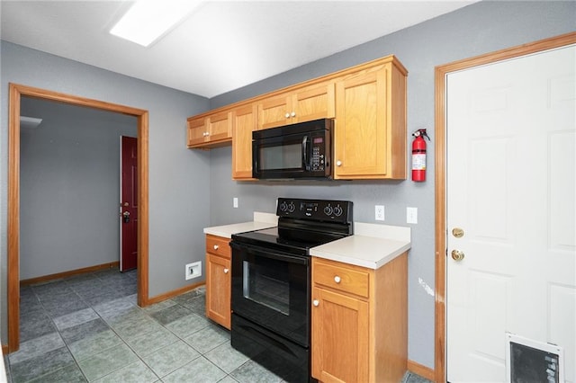 kitchen featuring black appliances, light tile patterned flooring, light countertops, and baseboards