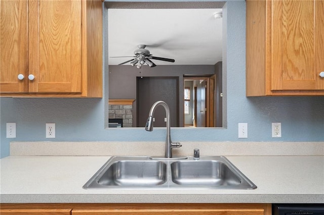 kitchen with dishwasher, light countertops, ceiling fan, and a sink