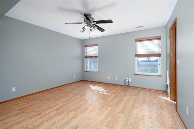 empty room featuring visible vents, baseboards, and wood finished floors