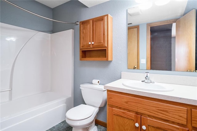 full bath with a textured wall, toilet, vanity, and shower / tub combination