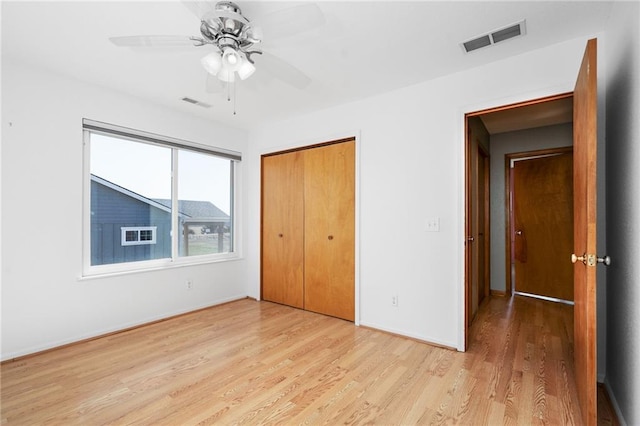 unfurnished bedroom featuring visible vents, baseboards, a closet, and light wood-style flooring