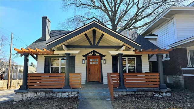 bungalow with a porch and a chimney