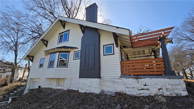 view of property exterior with a chimney and an attached garage