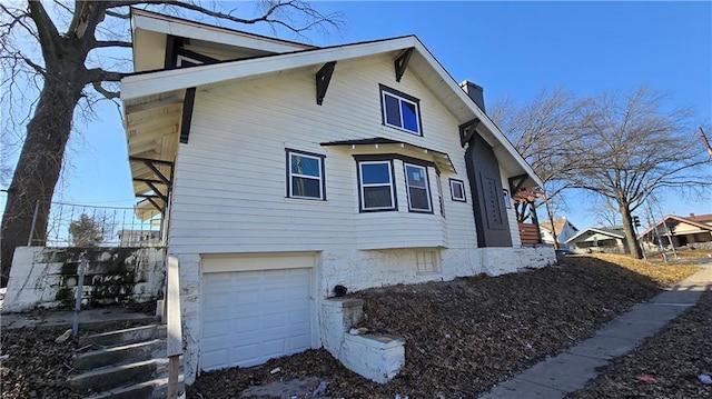 view of side of home featuring a garage and a chimney