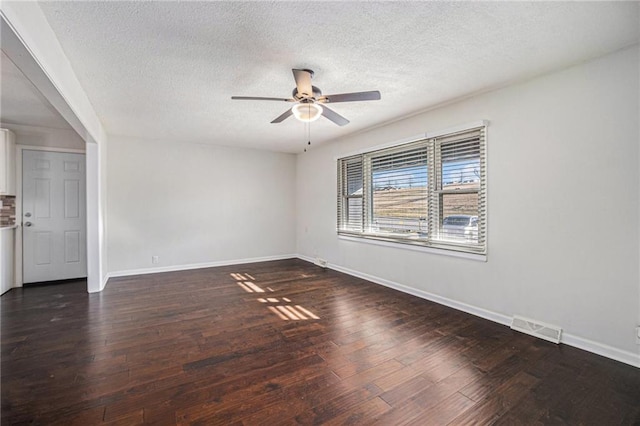 spare room with visible vents, wood-type flooring, baseboards, and a ceiling fan