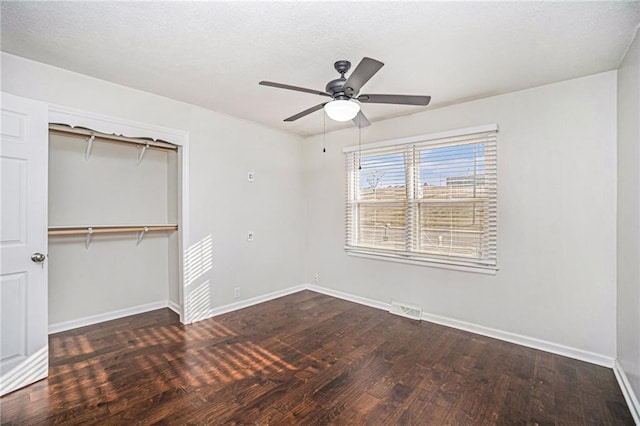 unfurnished bedroom featuring a closet, visible vents, baseboards, and wood finished floors