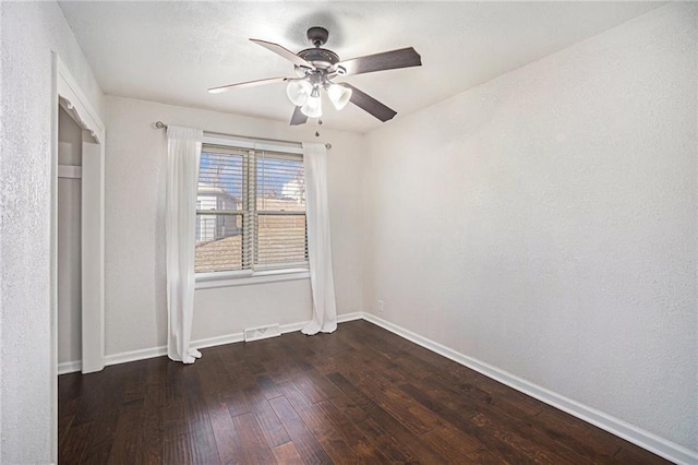 unfurnished bedroom featuring visible vents, ceiling fan, baseboards, and dark wood-style flooring