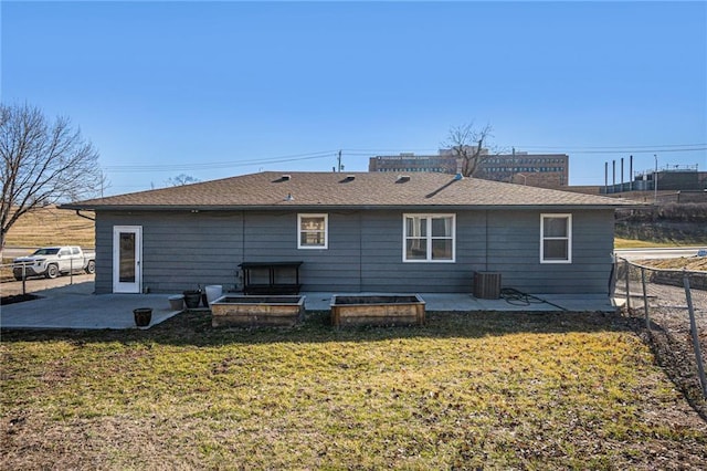 rear view of house with cooling unit, a patio area, fence, and a lawn