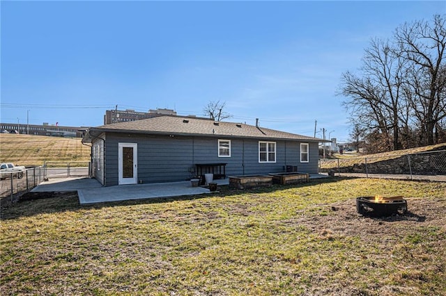 rear view of property with a yard, a patio, an outdoor fire pit, and a fenced backyard