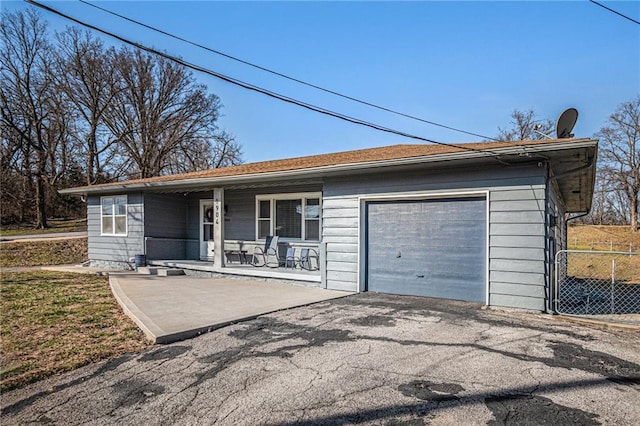 ranch-style house with aphalt driveway, a garage, and a porch