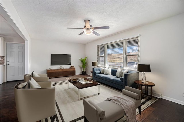 living room with baseboards, wood finished floors, a textured ceiling, and ceiling fan
