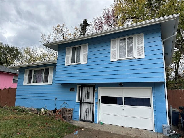 split level home with a garage and fence