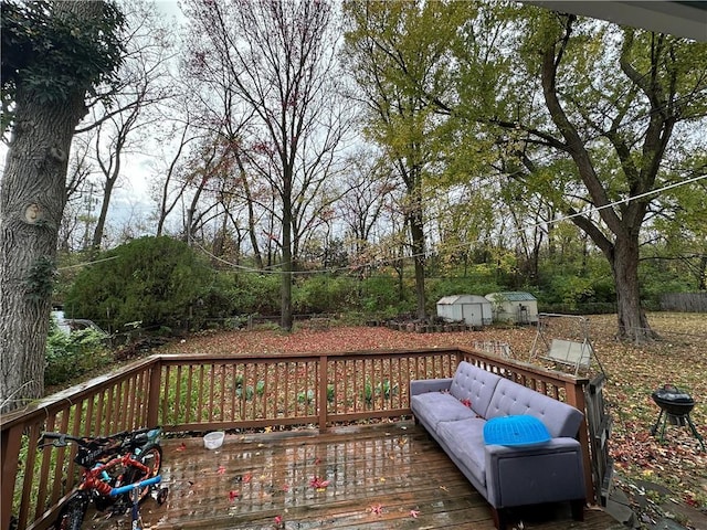 wooden deck featuring outdoor lounge area, a storage shed, and an outdoor structure
