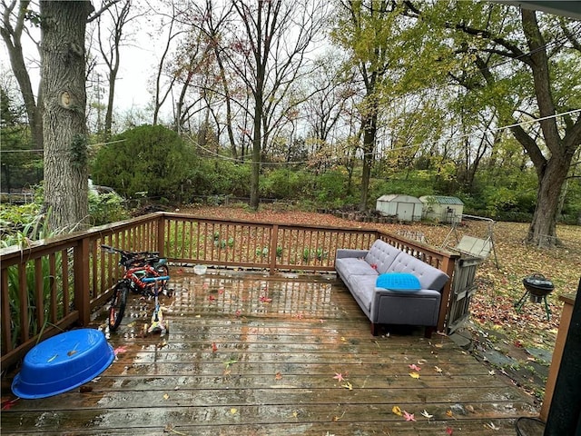 wooden terrace with an outbuilding, outdoor lounge area, and a storage shed