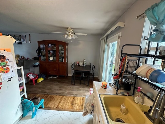 kitchen featuring baseboards, wood finished floors, and ceiling fan