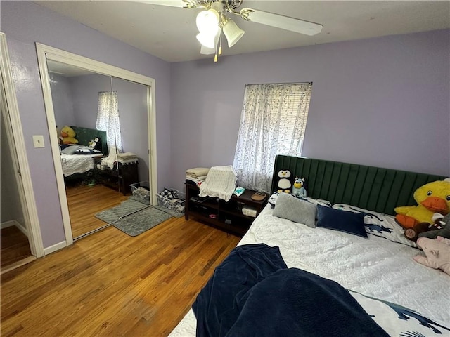 bedroom with a ceiling fan, wood finished floors, and a closet