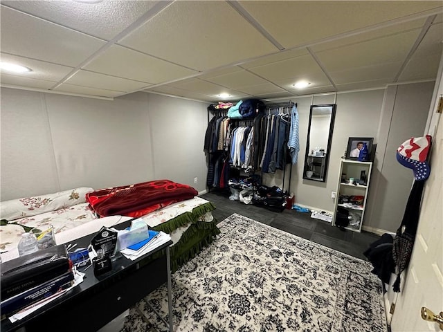 bedroom with baseboards and a drop ceiling