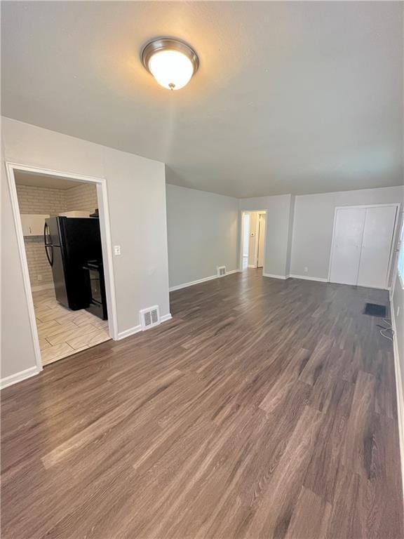 6645 Lydia Ave, Kansas City, MO 64131 - unfurnished living room with wood finished floors, visible vents, and baseboards