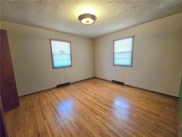 spare room featuring a textured ceiling, visible vents, and light wood-type flooring