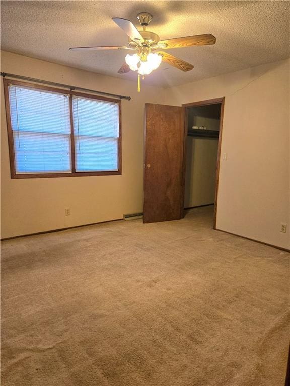 unfurnished bedroom with a ceiling fan, light colored carpet, and a textured ceiling