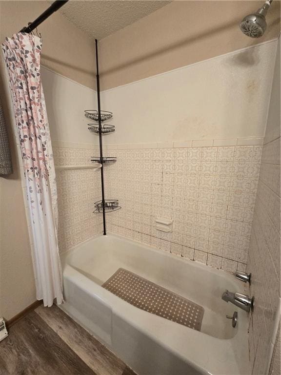 bathroom featuring wood finished floors, shower / bath combo, and a textured ceiling