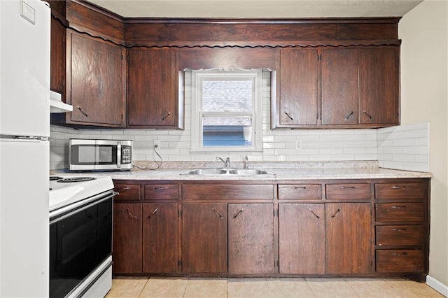 kitchen featuring a sink, under cabinet range hood, white appliances, light countertops, and decorative backsplash