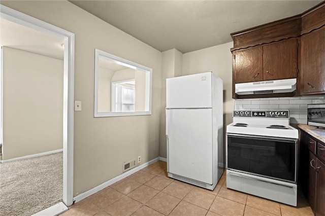 kitchen featuring white appliances, light countertops, dark brown cabinetry, under cabinet range hood, and tasteful backsplash