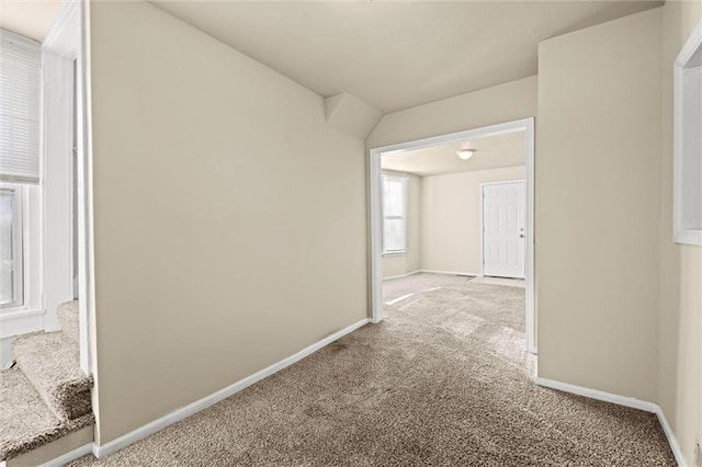 corridor featuring baseboards and carpet floors