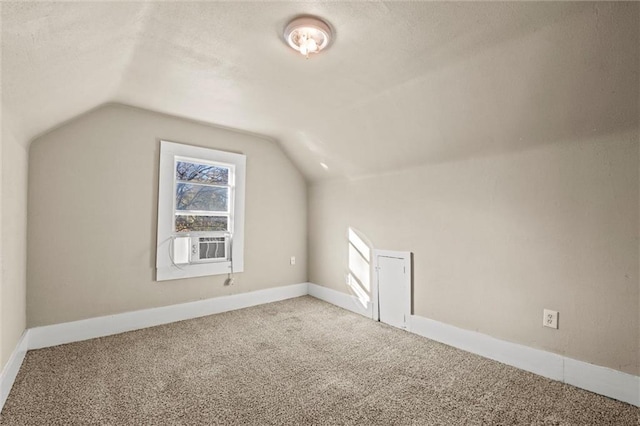 bonus room featuring baseboards, a textured ceiling, lofted ceiling, and carpet floors