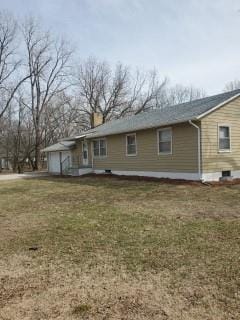 back of house with a garage and a yard