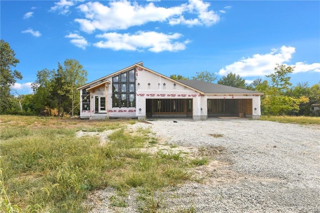 view of front of house featuring gravel driveway and an attached garage