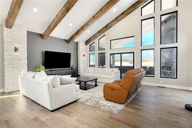 living area with beam ceiling, high vaulted ceiling, wood finished floors, recessed lighting, and baseboards