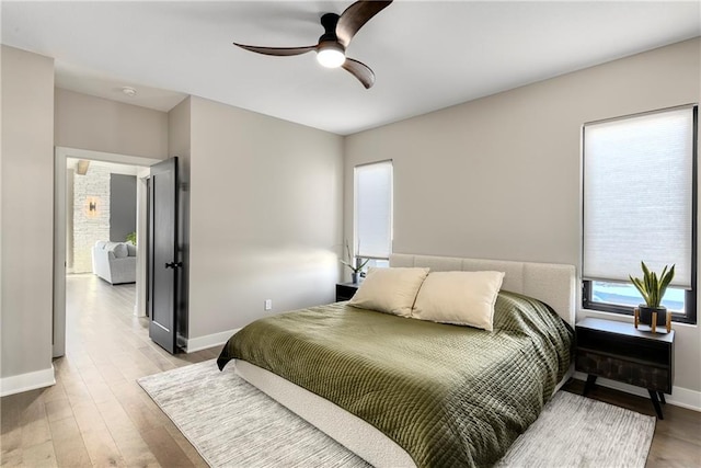 bedroom featuring wood finished floors, baseboards, and ceiling fan