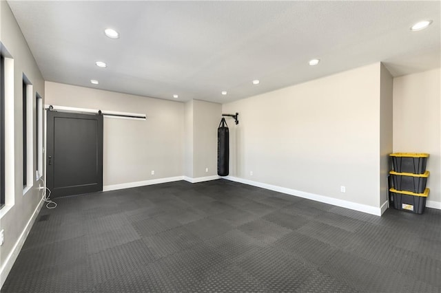 interior space featuring a barn door, recessed lighting, and baseboards