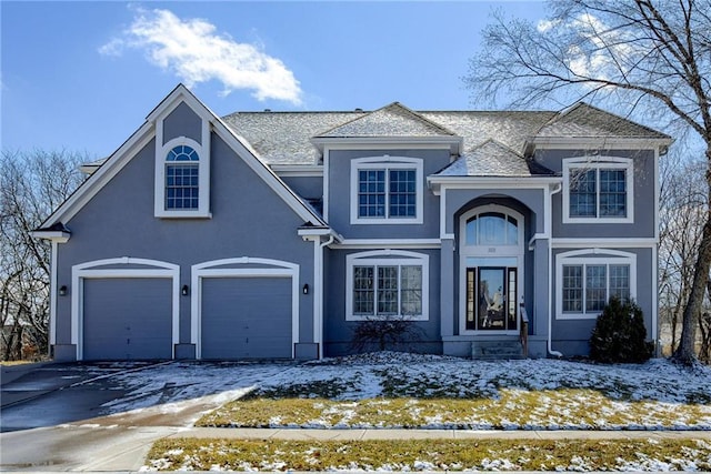 traditional-style home with aphalt driveway and stucco siding