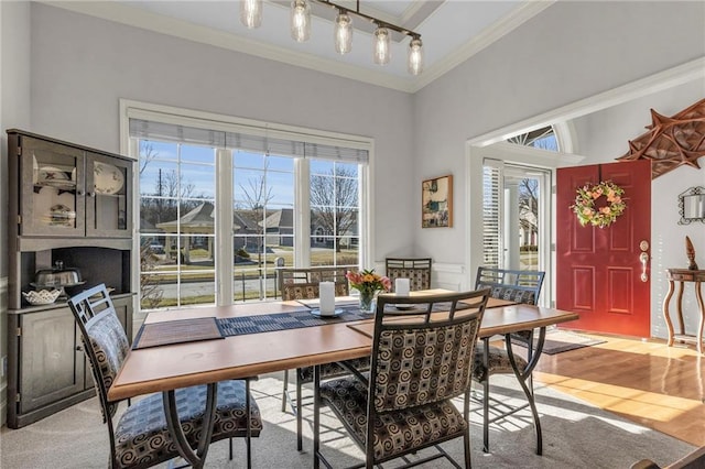 dining area featuring light wood-style flooring and crown molding