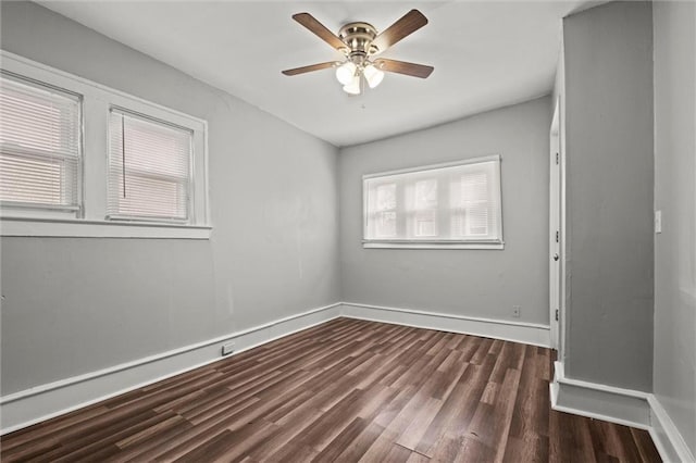 spare room with dark wood-style floors, ceiling fan, and baseboards