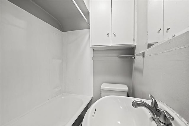 bathroom with tub / shower combination, a sink, and toilet