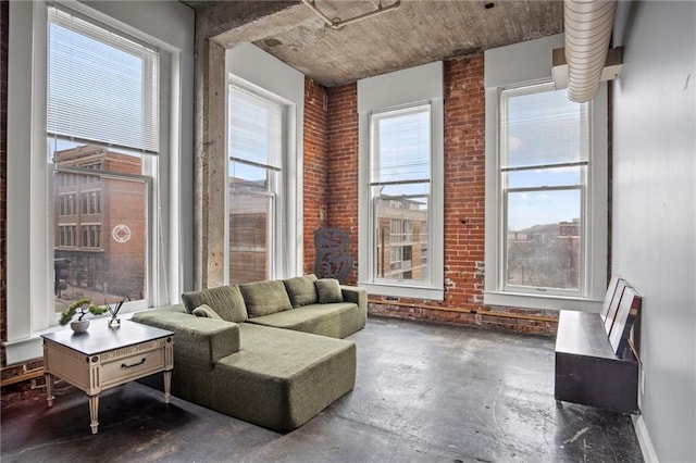 interior space with brick wall and unfinished concrete flooring