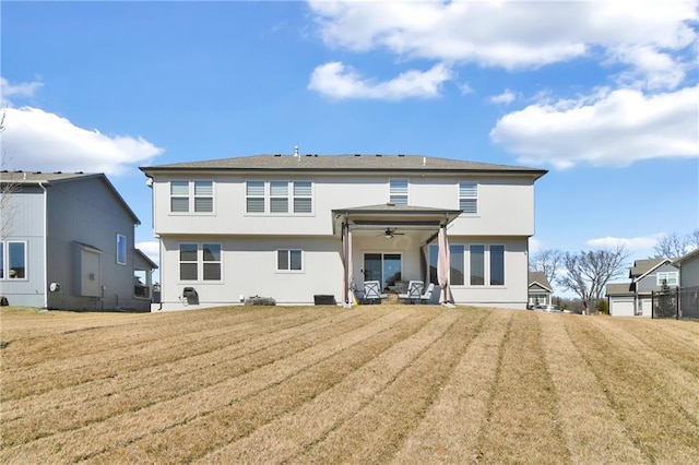 back of property featuring a yard, ceiling fan, and a patio area