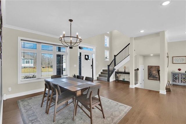 dining space featuring a notable chandelier, ornamental molding, wood finished floors, stairway, and baseboards