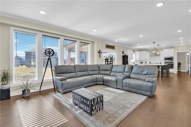 living area with dark wood-style floors, recessed lighting, crown molding, and baseboards