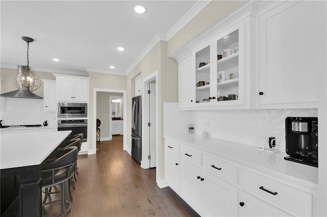 kitchen featuring stainless steel appliances, light countertops, glass insert cabinets, white cabinetry, and crown molding