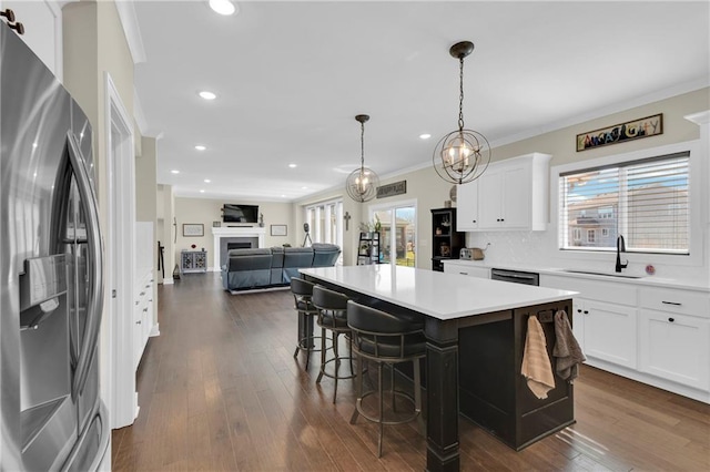 kitchen with dark wood finished floors, a fireplace, stainless steel fridge with ice dispenser, a sink, and crown molding