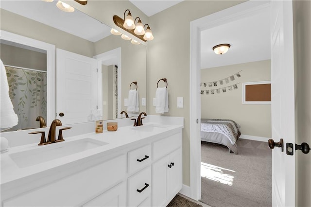 full bathroom featuring a sink, baseboards, ensuite bathroom, and double vanity