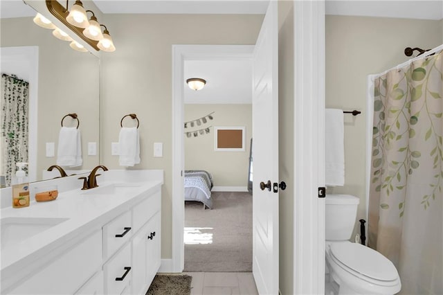 ensuite bathroom with ensuite bath, double vanity, toilet, and a sink