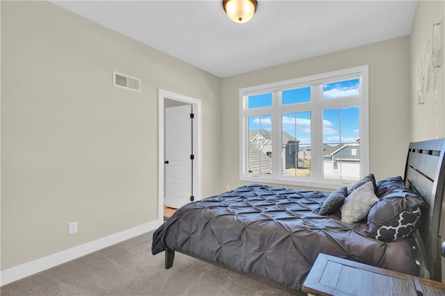 bedroom featuring visible vents, baseboards, and carpet