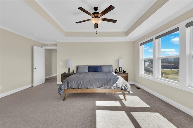 bedroom featuring baseboards, a raised ceiling, visible vents, and crown molding